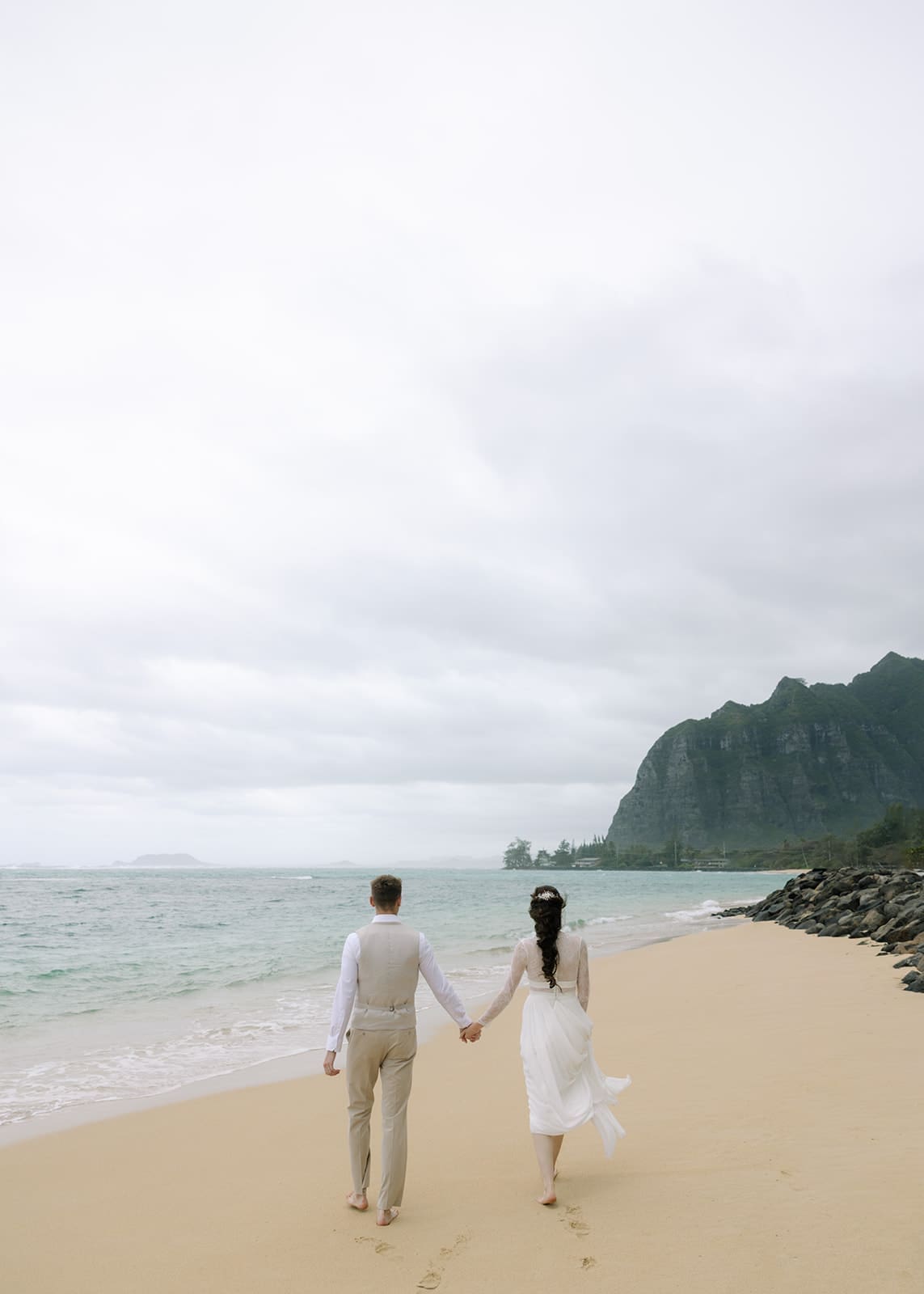 Couple walking at the beach after getting married in Oahu, Hawaii