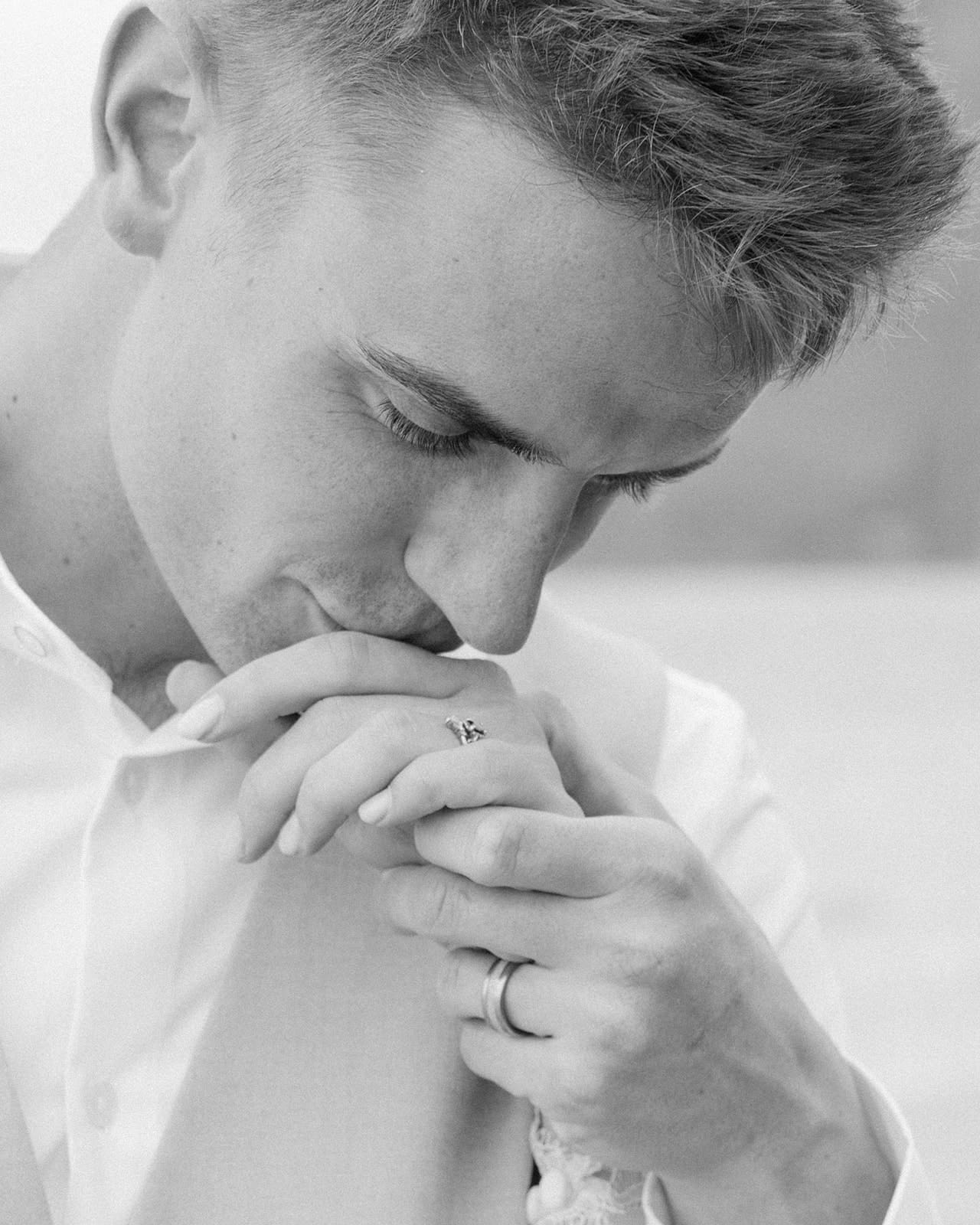 Groom kissing bride's hand in Oahu, Hawaii